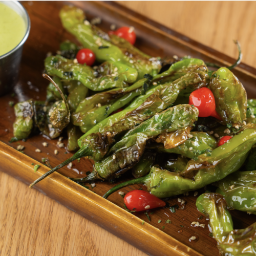 BLISTERED & CHARRED SHISHITO PEPPERS ~ GF on request / Vegan on request Charred Shishito peppers, lime, salt, olive oil, soy and a Cilantro-lime dipping sauce